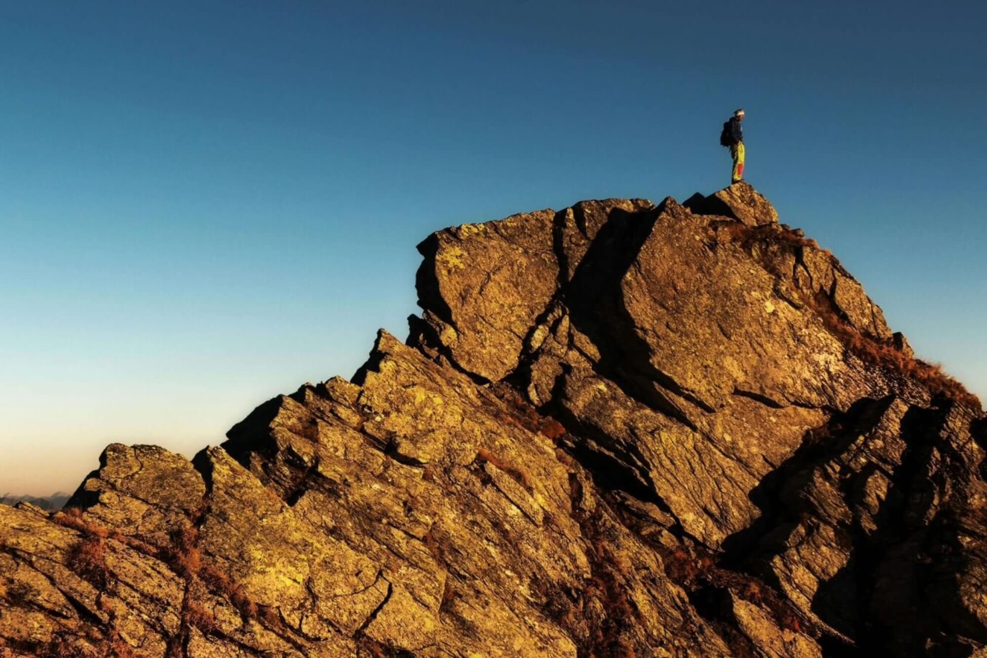 Erfolg im digitalen Marketing – Mann auf Berggipfel, symbolisiert führende Position in SEO, Webdesign und IT-Lösungen.